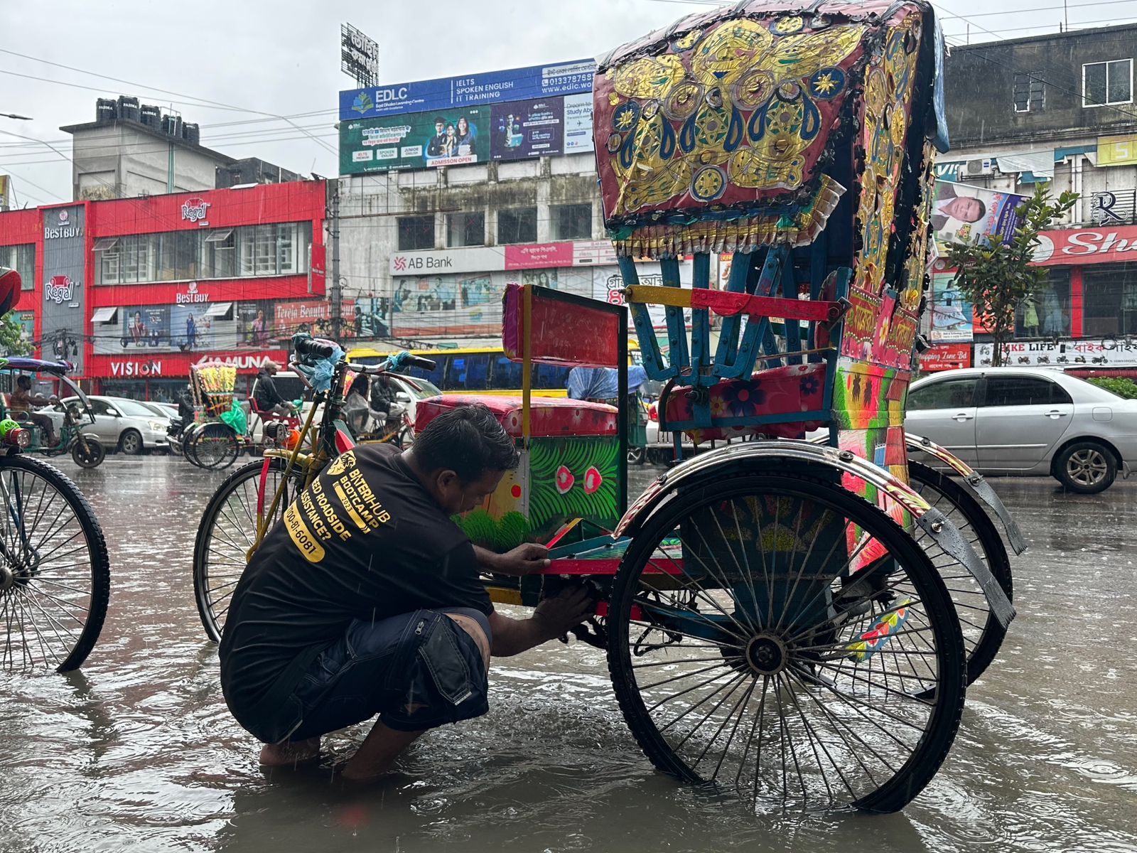  ⁠রাস্তায় জমে যাওয়া বৃষ্টির পানিতে রিকশার ধোয়ামোছা। ছবি- সাইফুল ইসলাম